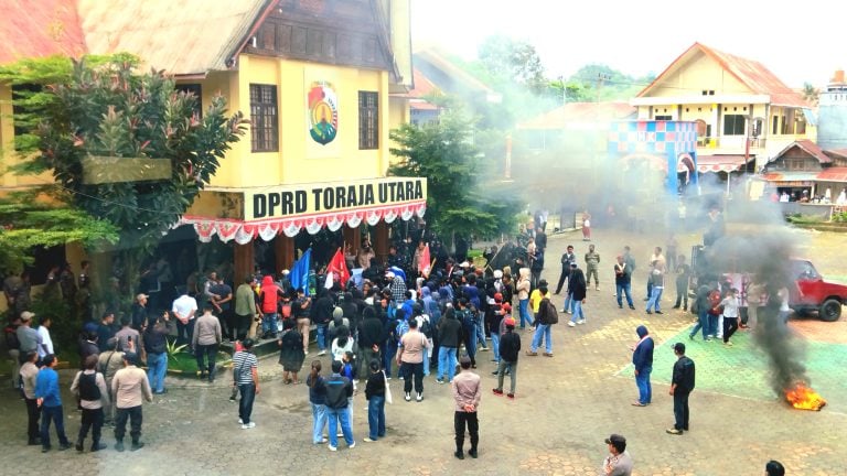 Ratusan mahasiswa sedang melakukan aksi mahasiswa Toraja Utara di depan kantor DPRD, membakar ban sebagai bentuk protes.