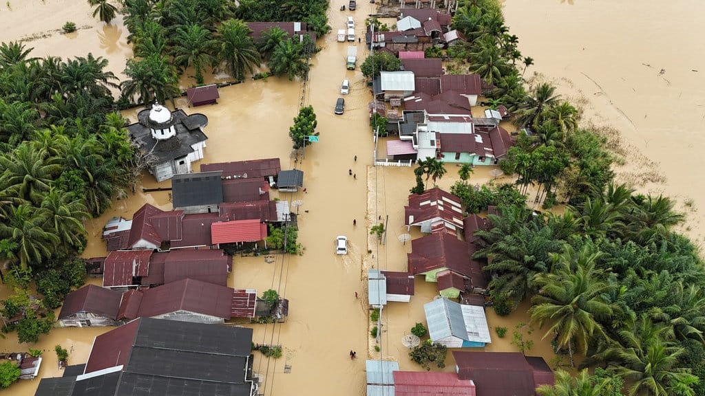Foto udara banjir besar di Sumatera yang merendam permukiman dan jalan utama saat upaya penanganan korban bencana Sumatera terus dilakukan.